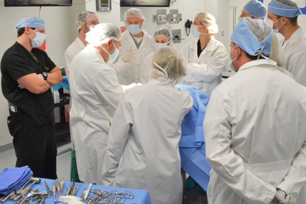 Image from our San Carlos Lab. Many medical professionals surrounding a table